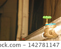 A green valve attached to the piping 142781147