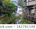 A residential area along the river and buildings with pipes. 142781148