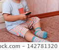 Baby with a mobile phone 142781320