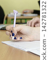 Schoolgirl writes with pen 142781322