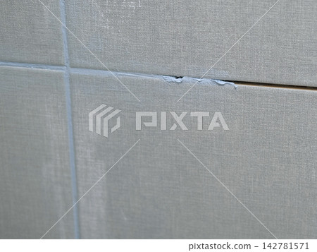 Worker using a rubber grout float to smooth grout between tiles. Carefully applying sealant to tiles joints. Workman hands smoothing caulk, using small tool to remove excess and create clean seam. Worker using a rubber grout float to smooth grout between tiles. Carefully applying sealant to tiles joints. Workman hands smoothing caulk, using small tool to remove excess and create clean seam. 142781571