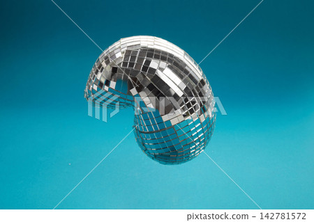 Melting disco ball creating abstract surreal reflection on turquoise 142781572