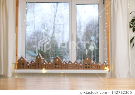 Empty wooden table top on blurred bokeh lights background. Festive winter holiday backdrop with out of focus advent countdown event for product display montage in cozy scandinavian room atmosphere. Empty wooden table top on blurred bokeh lights background. Festive winter holiday backdrop with out of focus advent countdown event for product display montage in cozy scandinavian room atmosphere. 142782360
