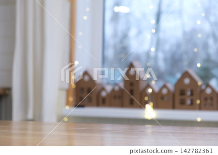 Empty wooden table top on blurred bokeh lights background. Festive winter holiday backdrop with out of focus advent countdown event for product display montage in cozy scandinavian room atmosphere. Empty wooden table top on blurred bokeh lights background. Festive winter holiday backdrop with out of focus advent countdown event for product display montage in cozy scandinavian room atmosphere. 142782361