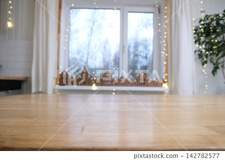 Empty wooden table top on blurred bokeh lights background. Festive winter holiday backdrop with out of focus advent countdown event for product display montage in cozy scandinavian room atmosphere. Empty wooden table top on blurred bokeh lights background. Festive winter holiday backdrop with out of focus advent countdown event for product display montage in cozy scandinavian room atmosphere. 142782577