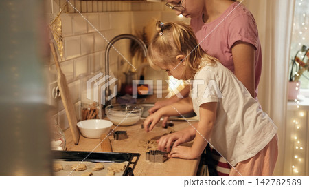 Two sisters making cookies together in festive Christmas kitchen Two sisters making cookies together in festive Christmas kitchen 142782589