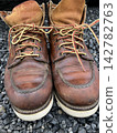 Photo 2 shows leather work boots placed on gravel. 142782763