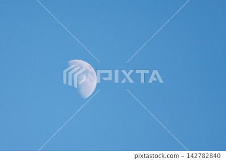 A white crescent moon floating in the blue sky A white crescent moon floating in the blue sky 142782840