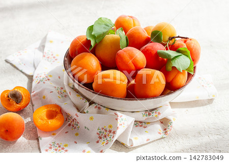 Fresh apricots in a bowl, on a bright table, natural light, top view, no people, Fresh apricots in a bowl, on a bright table, natural light, top view, no people, 142783049