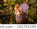happy girl near a decorated New Year's tree 142783289