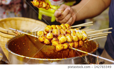 Seller Preparing Street Food At Night Market, Food Vendor And Asian Street Snack Concept Seller Preparing Street Food At Night Market, Food Vendor And Asian Street Snack Concept 142783349