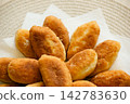 Freshly baked golden pirozhki pies placed on plate for bakery banner 142783630