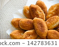 Freshly baked golden pirozhki pies placed on plate for bakery banner 142783631