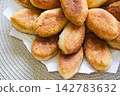 Freshly baked golden pirozhki pies placed on plate for bakery banner 142783632