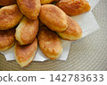 Freshly baked golden pirozhki pies placed on plate for bakery banner 142783633