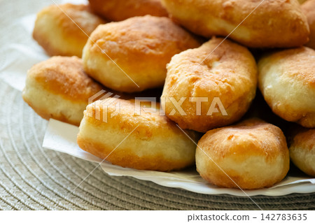 Golden fried pirozhki pies stacked on plate for bakery menu Golden fried pirozhki pies stacked on plate for bakery menu 142783635