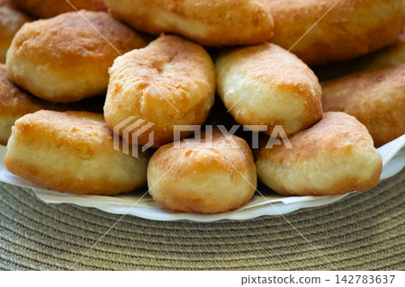 Golden fried pirozhki pies stacked on plate for bakery menu Golden fried pirozhki pies stacked on plate for bakery menu 142783637