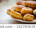 Golden homemade fried pirozhki pies on plate for cafe menu background 142783638