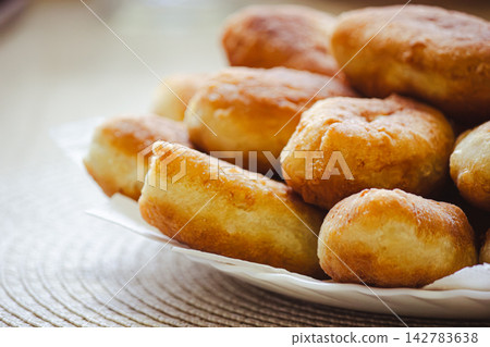 Golden homemade fried pirozhki pies on plate for cafe menu background Golden homemade fried pirozhki pies on plate for cafe menu background 142783638