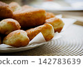 Golden homemade fried pirozhki pies on plate for cafe menu background 142783639