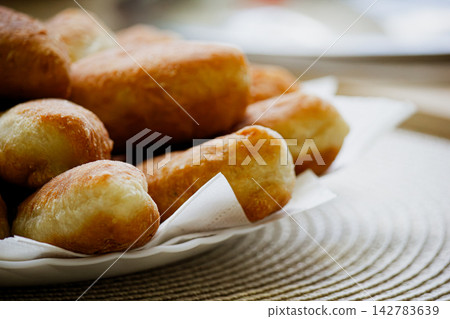 Golden homemade fried pirozhki pies on plate for cafe menu background Golden homemade fried pirozhki pies on plate for cafe menu background 142783639