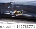 Close-up of a dark blue car door and rocker panel with a deep dent and torn metal exposing internal parts after a collision. Insurance claim concept 142783771