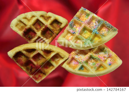 A close-up and overhead view of colorful waffles. 142784167