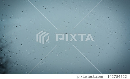 Raindrops streak across a misty window pane Raindrops streak across a misty window pane 142784522