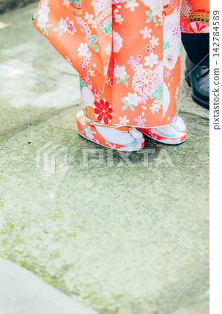 The feet of a girl in a kimono walking along a cobblestone path The feet of a girl in a kimono walking along a cobblestone path 142784589