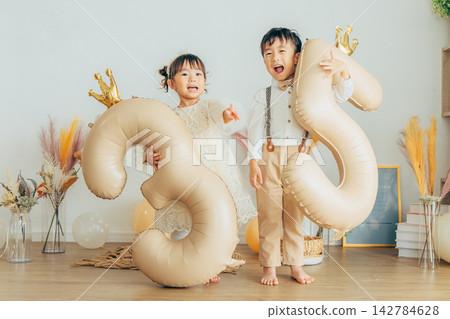 一個孩子拿著一個代表自己年齡的氣球。 142784628