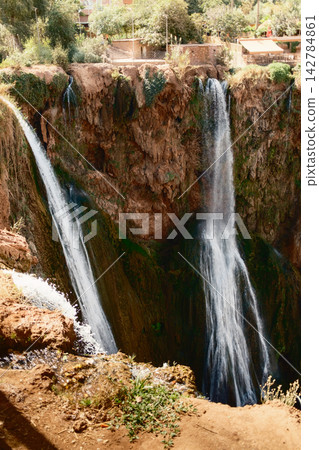 Vertical Waterfall Flow in Sunlit Gorge Vertical Waterfall Flow in Sunlit Gorge 142784861