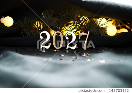 New Year's holiday background with bokeh with the number of the year 2027. New Year's holiday background with bokeh with the number of the year 2027. 142785352