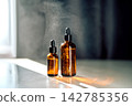 Skincare bottles presenting essence and atomized mist droplets 142785356