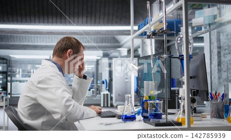 Dissatisfied scientist struggles to figure out complicated experiment data in laboratory. Confused and unsuccessful man dealing with challenges of biotechnology and genetics research. Dissatisfied scientist struggles to figure out complicated experiment data in laboratory. Confused and unsuccessful man dealing with challenges of biotechnology and genetics research. 142785939