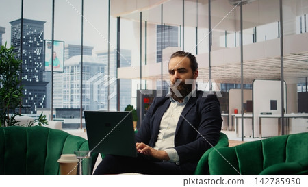 Entrepreneur in his luxurious office working on pc for productivity, showcasing empowerment while he manages company investments. Chief executive officer in his personal office. Camera A. Entrepreneur in his luxurious office working on pc for productivity, showcasing empowerment while he manages company investments. Chief executive officer in his personal office. Camera A. 142785950