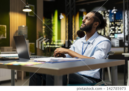 Worker at office desk thinking how to complete computer tasks before deadline, working overnight. Middle Eastern Arab man using notebook, researching data for company project, Worker at office desk thinking how to complete computer tasks before deadline, working overnight. Middle Eastern Arab man using notebook, researching data for company project, 142785973