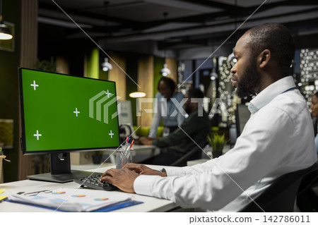 Isolated chroma key on desktop pc with black analyst analyzing KPI metrics, applying a strategic mindset to business development plans. Support innovation and goals achievement. Isolated chroma key on desktop pc with black analyst analyzing KPI metrics, applying a strategic mindset to business development plans. Support innovation and goals achievement. 142786011