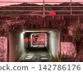 The underpass leading through the mountains at dusk, and the lights of cars. 142786176