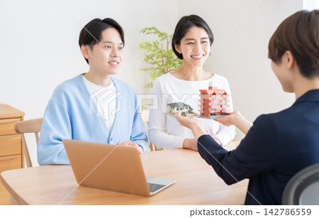 A couple considering buying a house and a real estate agent A couple considering buying a house and a real estate agent 142786559