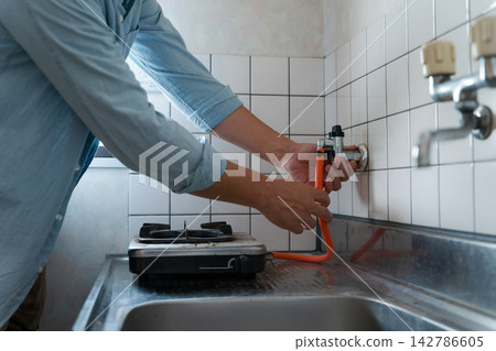 A male worker inspecting the gas supply. A male worker inspecting the gas supply. 142786605