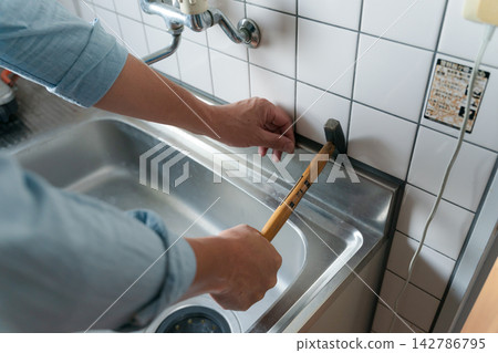 一名男工人正在裝修廚房。 一名男工人正在裝修廚房。 142786795