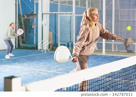 Padel game - woman with partners plays on tennis court Padel game - woman with partners plays on tennis court 142787011