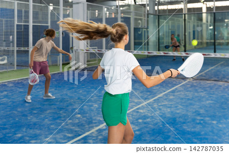Girl tennis player playing padel tennis Girl tennis player playing padel tennis 142787035