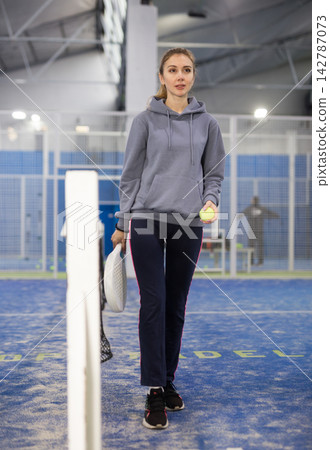 Woman padel player at net in court Woman padel player at net in court 142787073