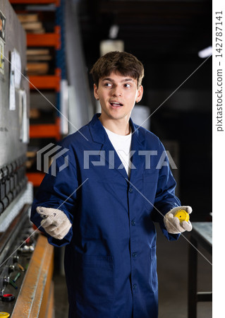 Portrait of male worker in a robe in workshop of metallurgical plant Portrait of male worker in a robe in workshop of metallurgical plant 142787141