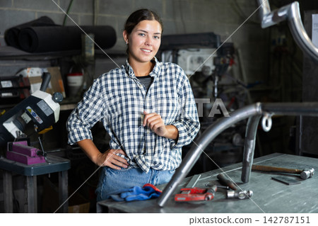 Young woman posing in metallurgical workshop Young woman posing in metallurgical workshop 142787151