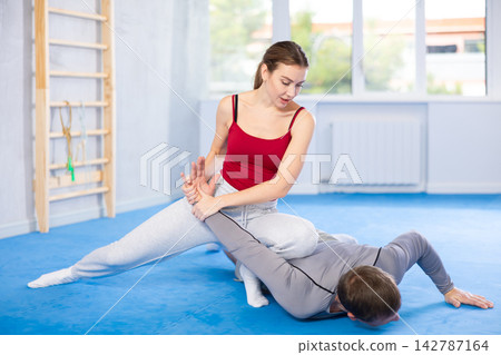Young girl and middle-aged man practicing arm twist technique during self-defense courses 142787164