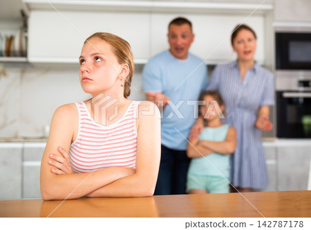 Parents scolding teenager daughter in kitchen Parents scolding teenager daughter in kitchen 142787178