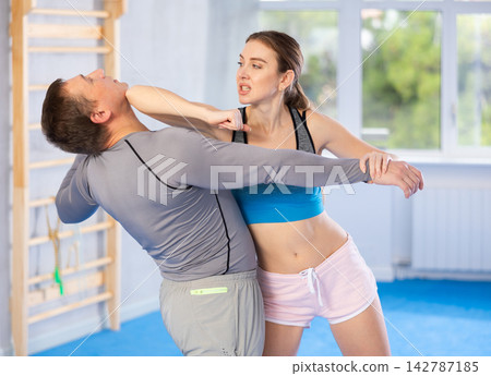 Woman and man practicing self defense techniques Woman and man practicing self defense techniques 142787185