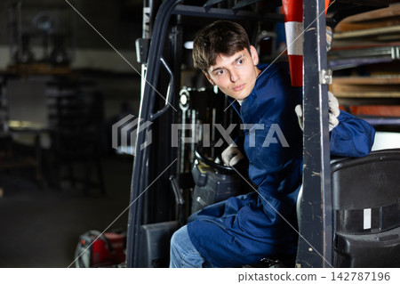 Young male worker working on forklift at metallurgical plant Young male worker working on forklift at metallurgical plant 142787196